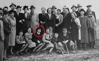 Black and white photograph of men and women stood and sat two rows